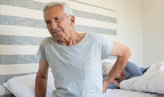 Older man with sore back in bed