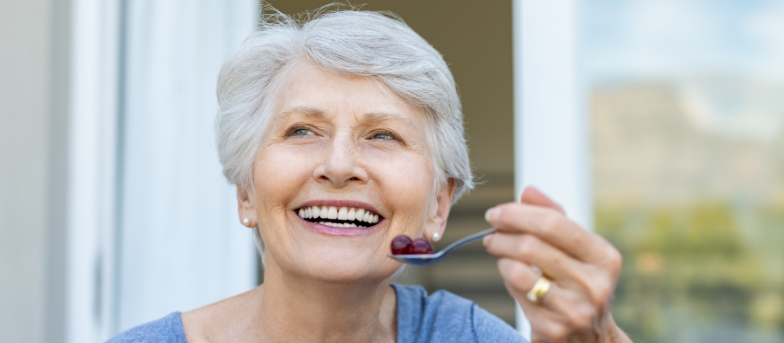 Smiling senior women eating grapes